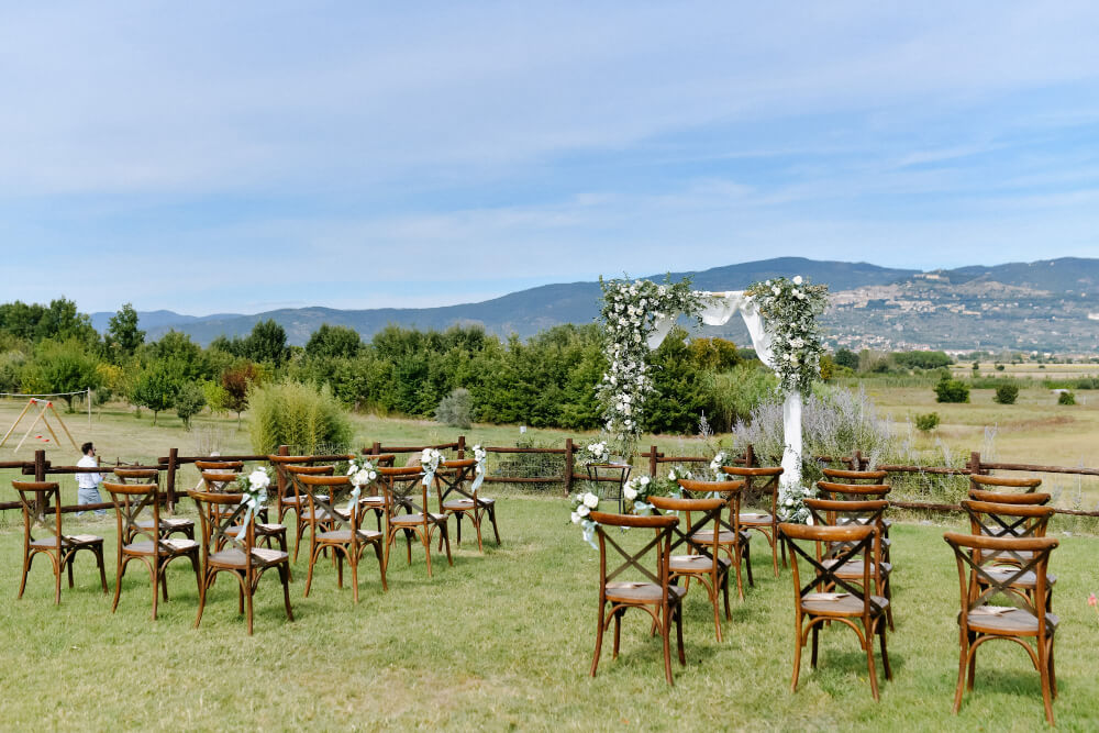 Ceremonial wedding archway and chiavari chairs for guests outdoors