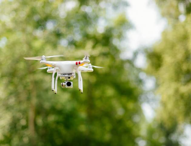 Copter with digital camera flying high in the air, taking photos