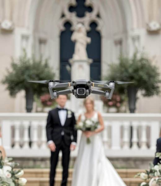 Little flying drone in a wedding flying over the white chrs with de groom and the bride