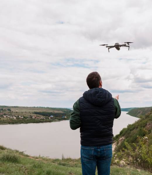 Young man piloting a drone in nature